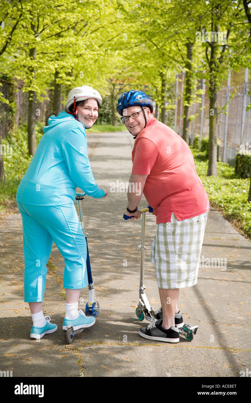 Couple riding scooters Stock Photo