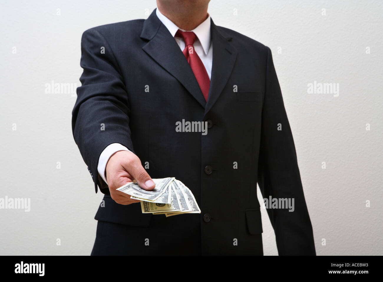 Businessman holding out handful of money Stock Photo