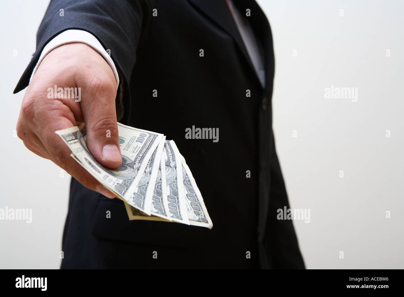 Businessman holding out handful of money Stock Photo