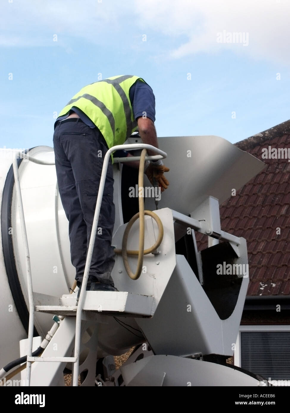 Ready mixed concrete lorry completed delivery to construction site driver washing out drum Stock
