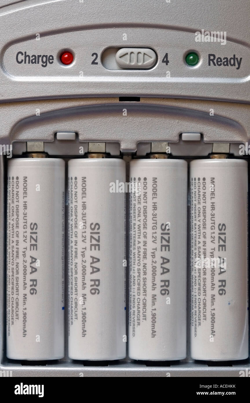 Four Ready To Use Rechargeable Batteries In Fast Charger Stock Photo