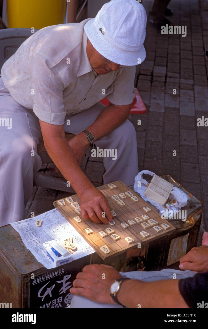 Two men face off during a board game of shogi in an Osaka city park Stock Photo