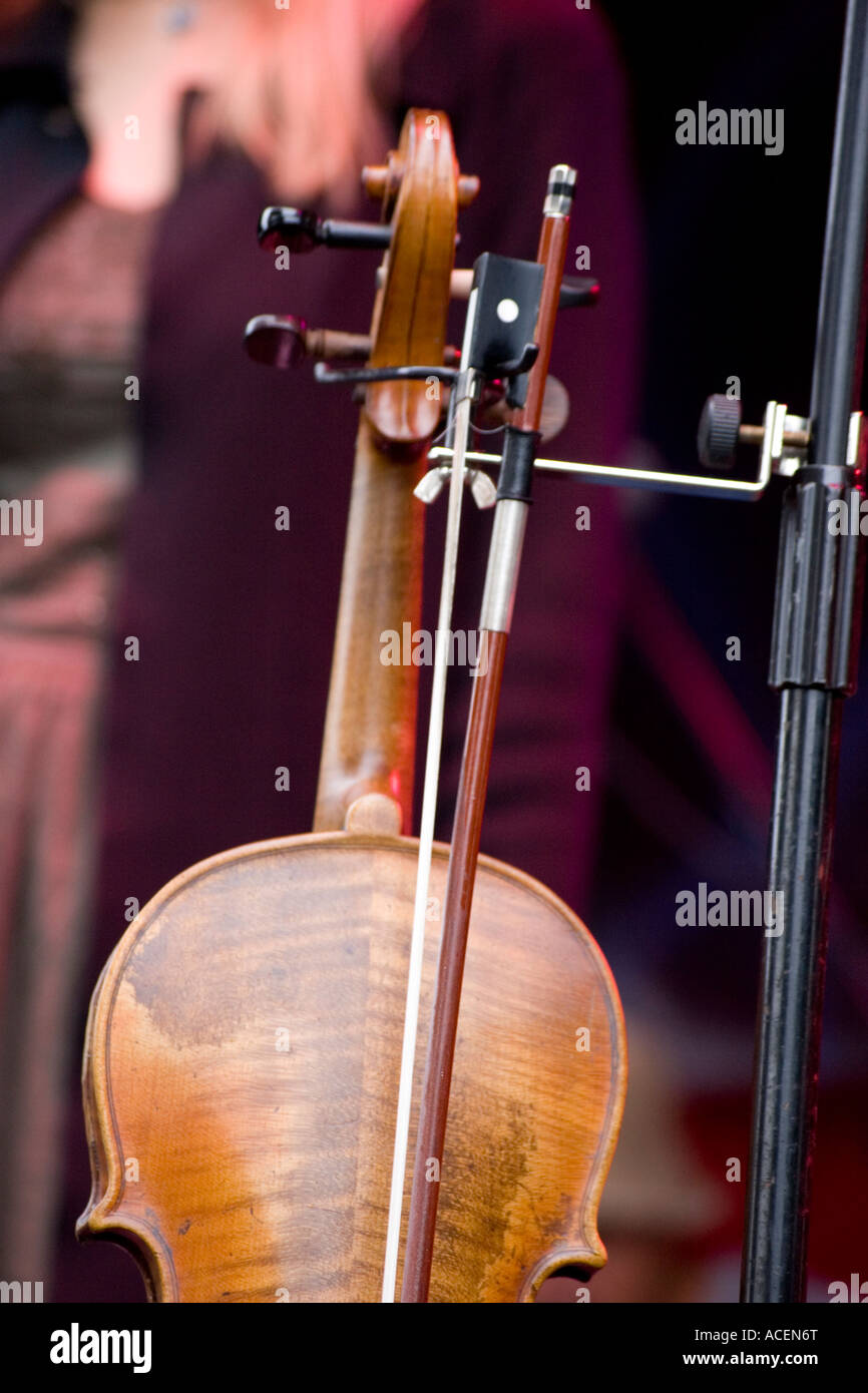 Violin hanging on stand on stage at Irish music concert Stock Photo