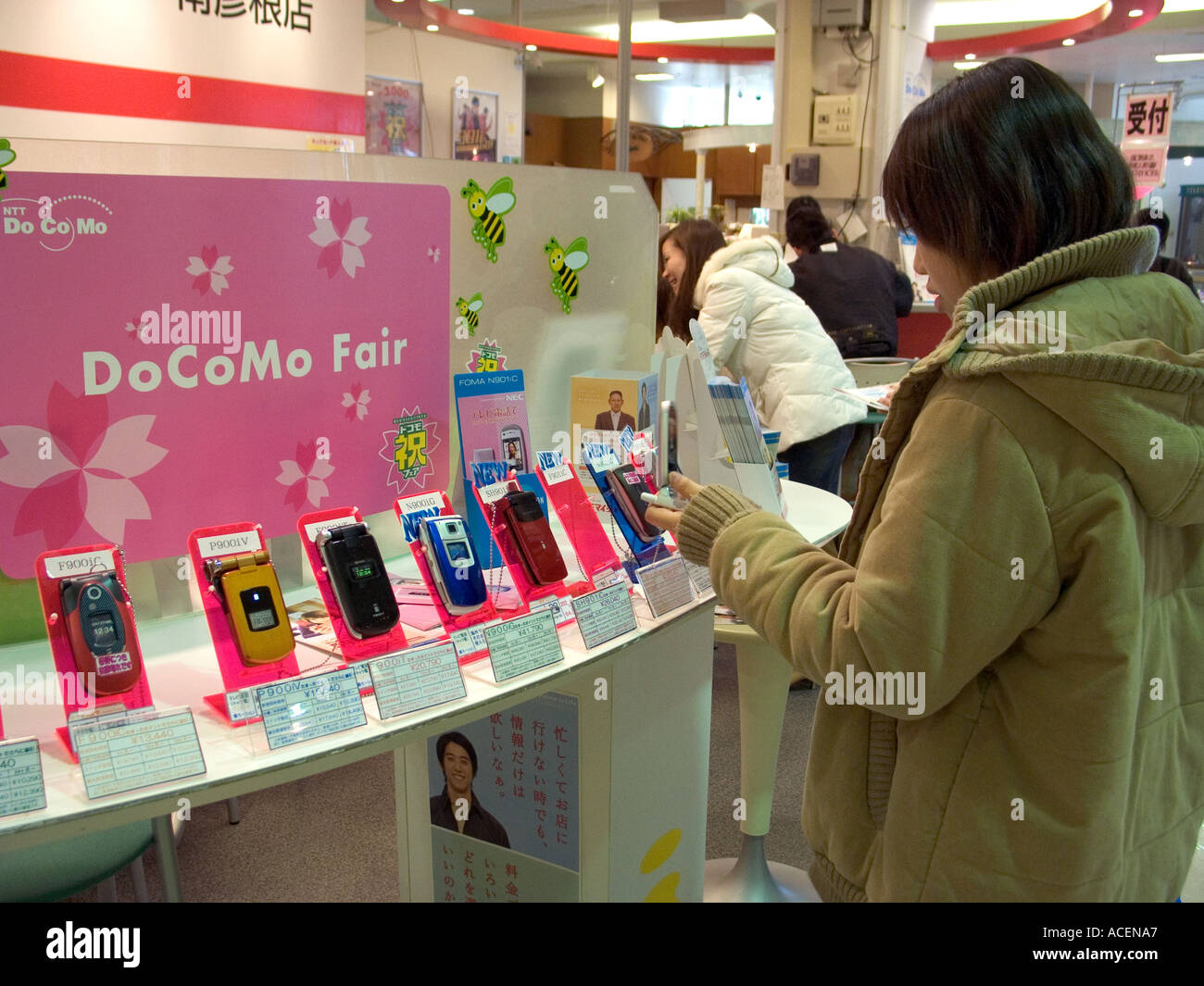 Customer inspecting the latest in mobile telephone technology at Japanese department store DoCoMo cell phone display counter Stock Photo