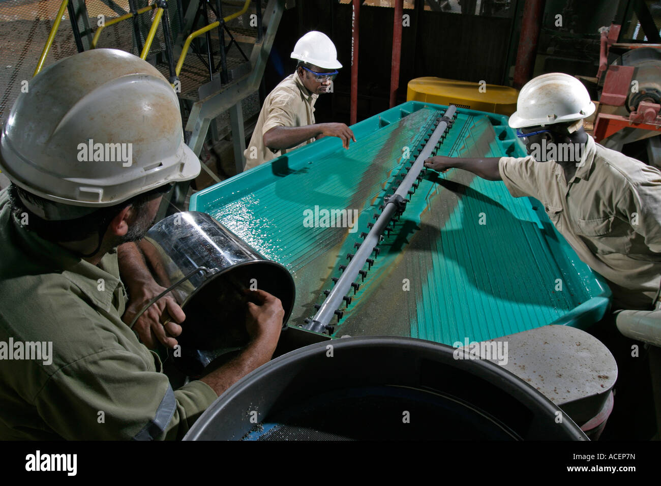 Cleaning gravity concentrate showing separation of gold metal using Gemini vibrating table, Ghana, West Africa Stock Photo