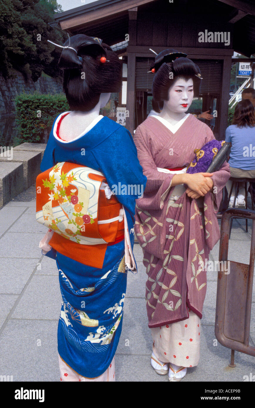Kyoto geisha of geiko in kimono socializing with each other in a garden Stock Photo