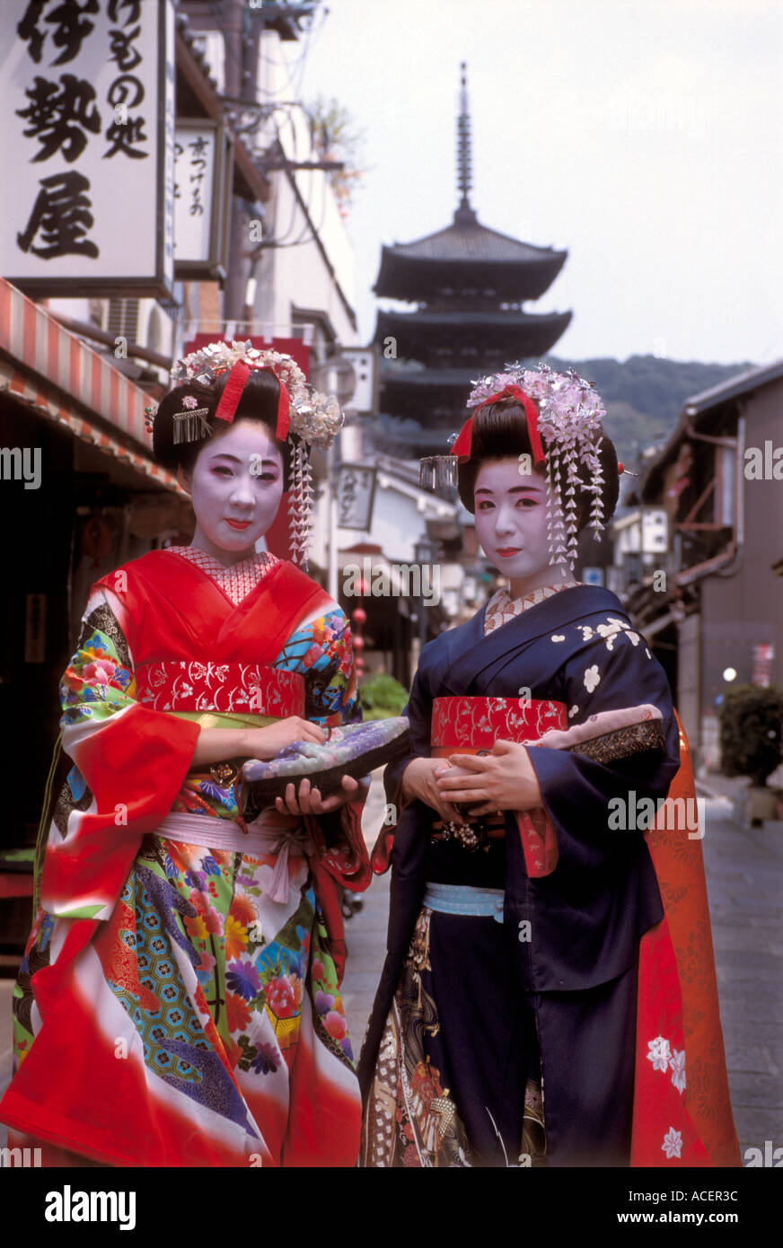 Two maiko or geisha in training strolling along a backstreet in Kyoto Stock Photo