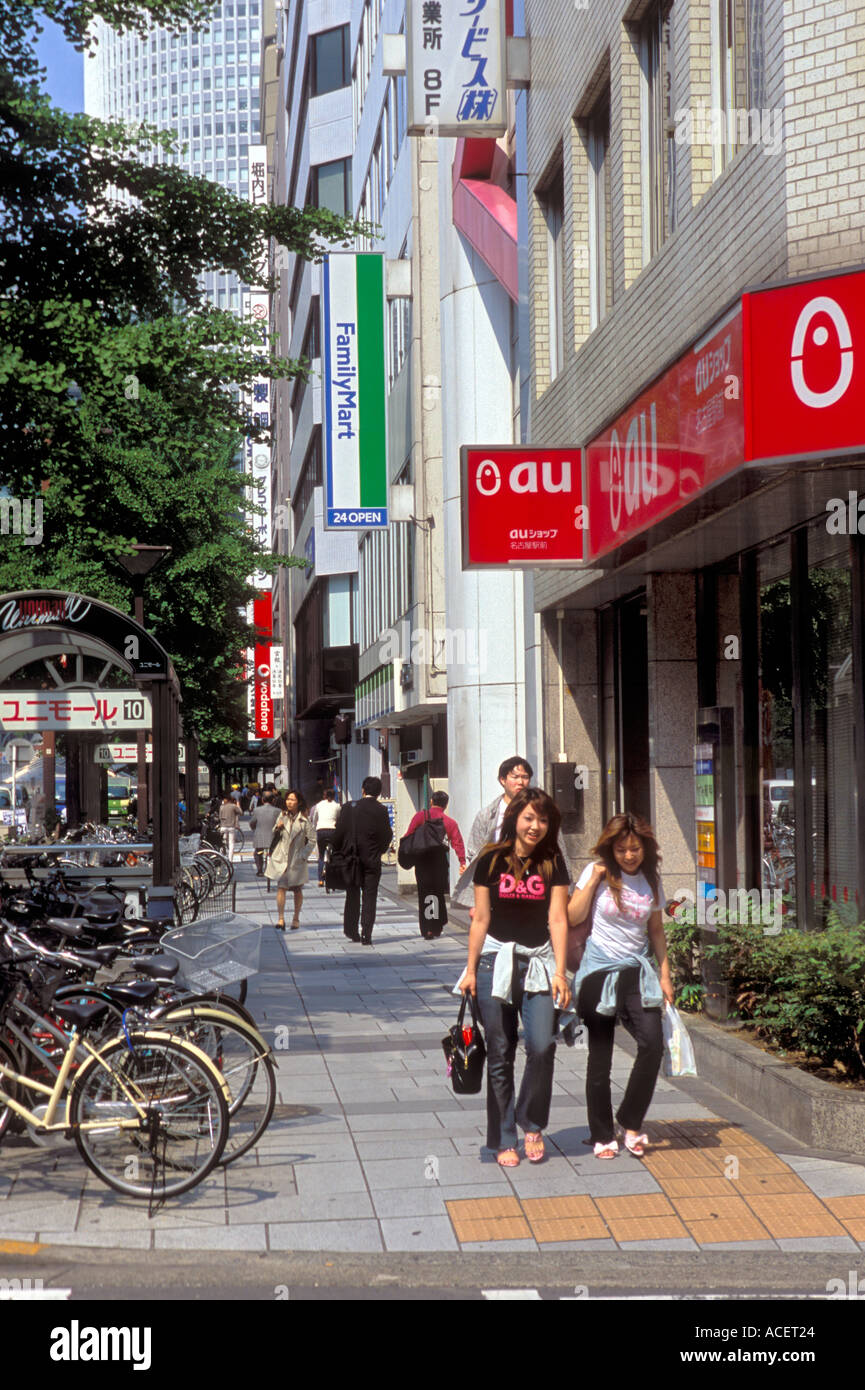 Two girls walking down street through business district in downtown Nagoya Stock Photo