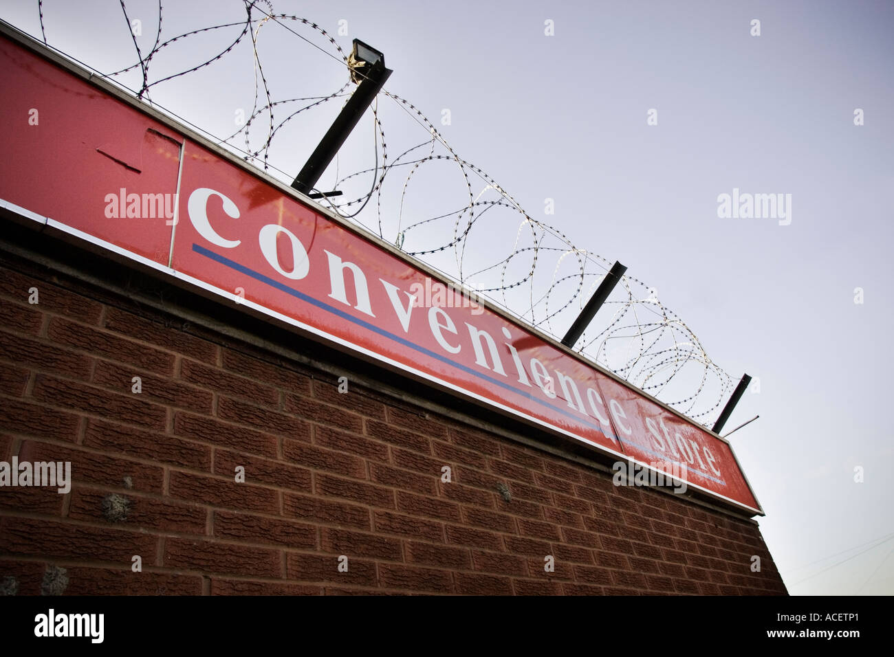 Security - Inner city convenience store with added security barbed wire Stock Photo