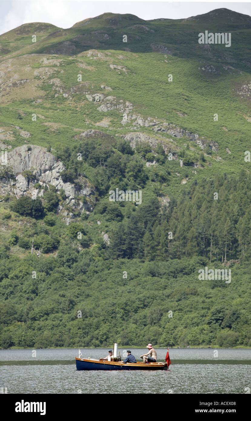 Three men in a steam powered boat on Ullswater lake Cumbria England UK