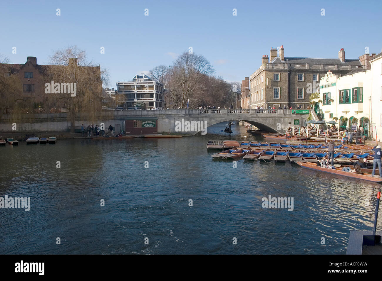 Visitors and Students enjoy winter sunshine on the River Cam by Silver Street Bridge and Queens College Stock Photo