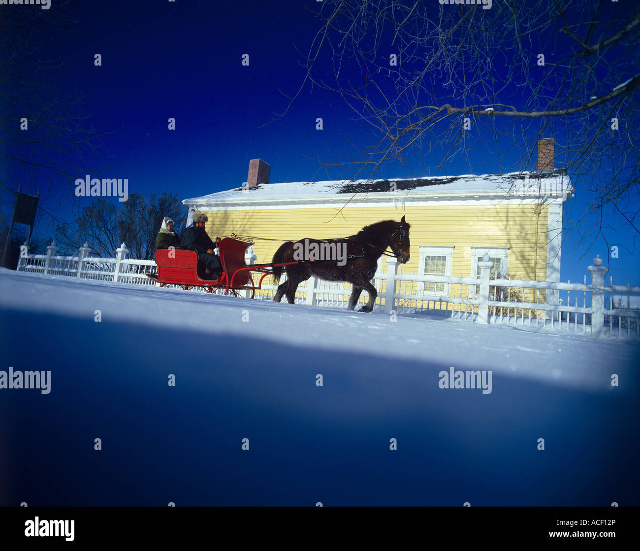 Sleigh ride yellow farm house snow Stock Photo - Alamy