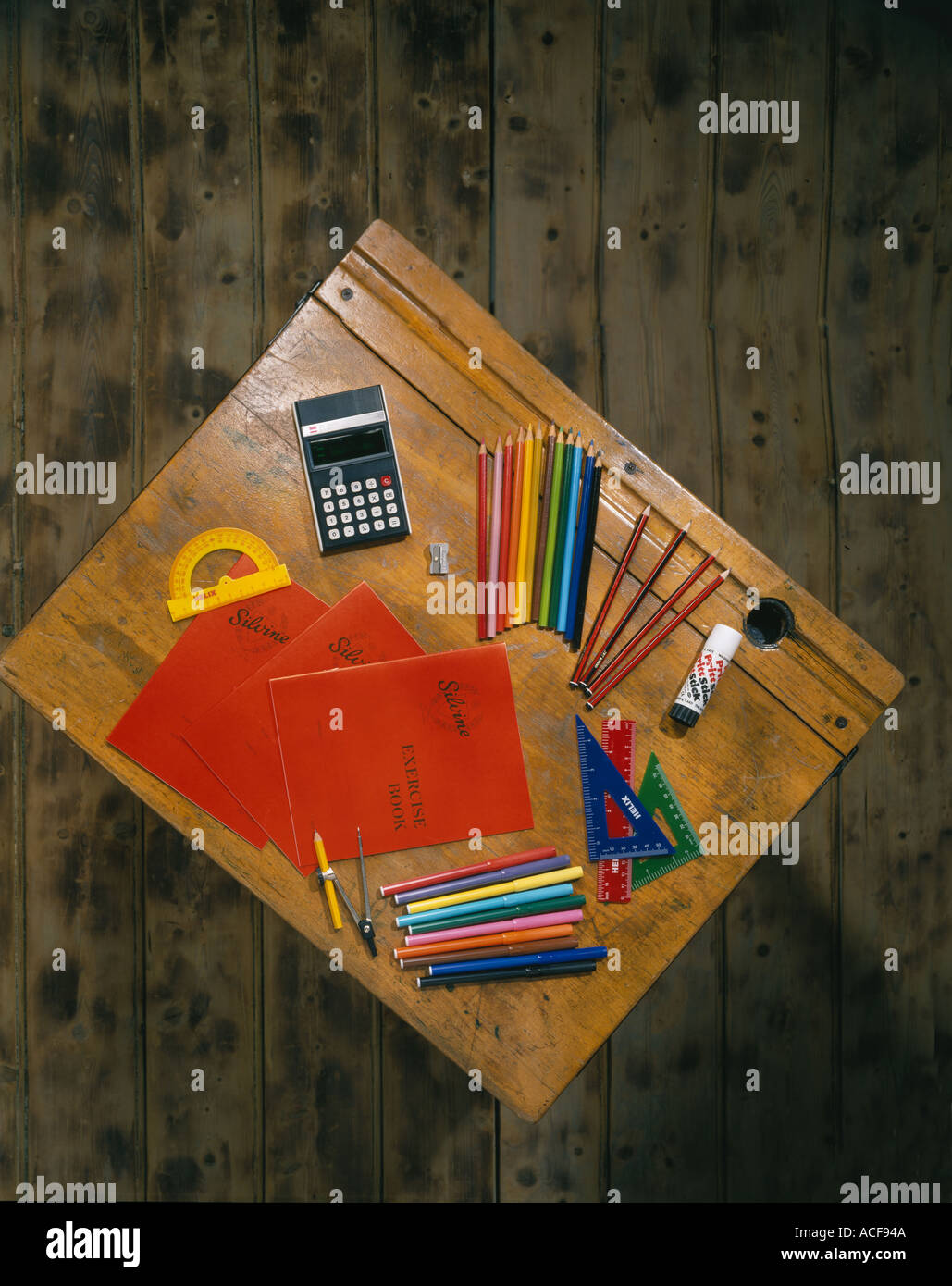 School desk with exercise book pencils and measuring instruments Stock Photo