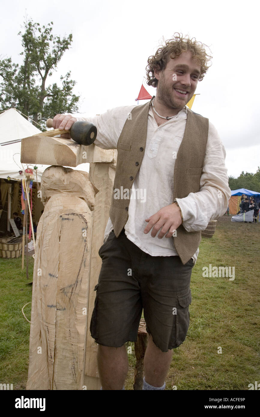 Carpenter carving a wood sculpture in the green fields, Glastonbury ...
