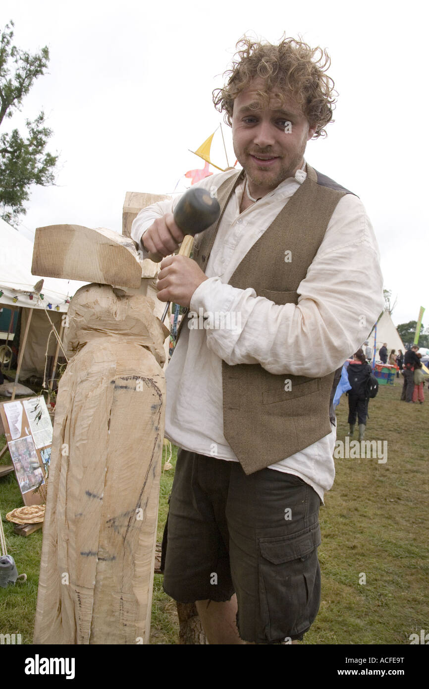 Carpenter carving a wood sculpture in the green fields, Glastonbury ...