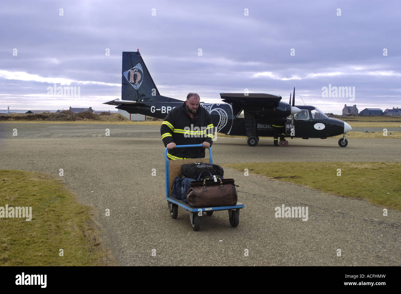 Baggage handler and Aircraft on the runway at North Ronaldsay Airport Orkney Scotland Stock Photo