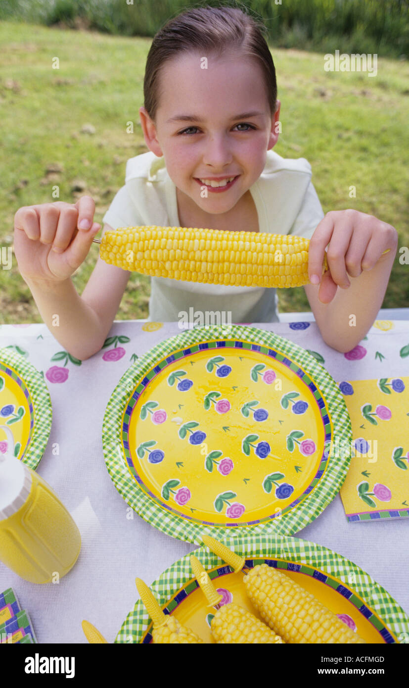Girl 9 yrs old at picnic eating corn on the cob, Washington State USA