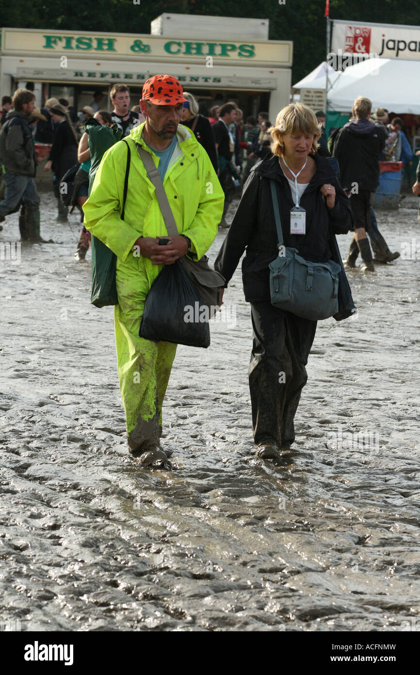 A couple walking through the mud, In the Food market area at the Glastonbury festival 2007 Stock Photo