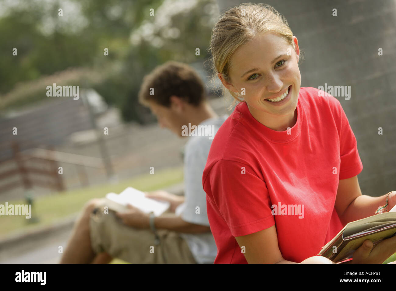 Smiling student reading outside Stock Photo
