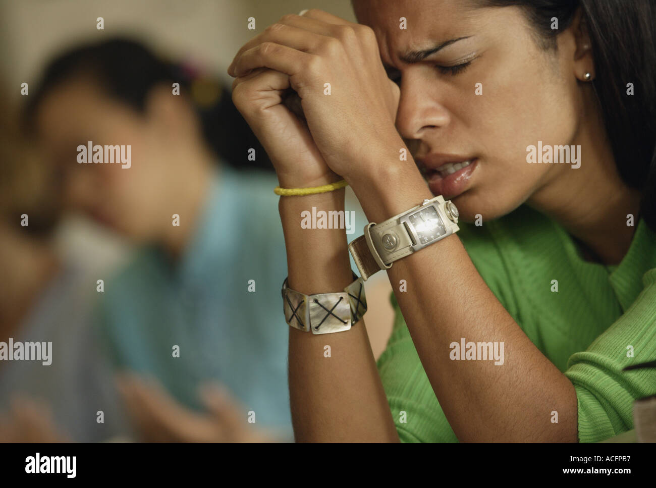 Woman praying with hands clasped Stock Photo