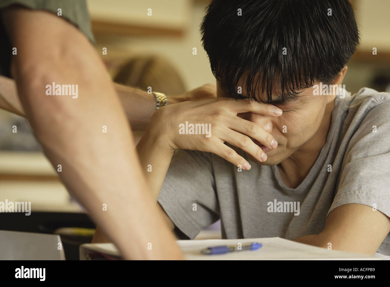 Student in distress crying at their desk Stock Photo