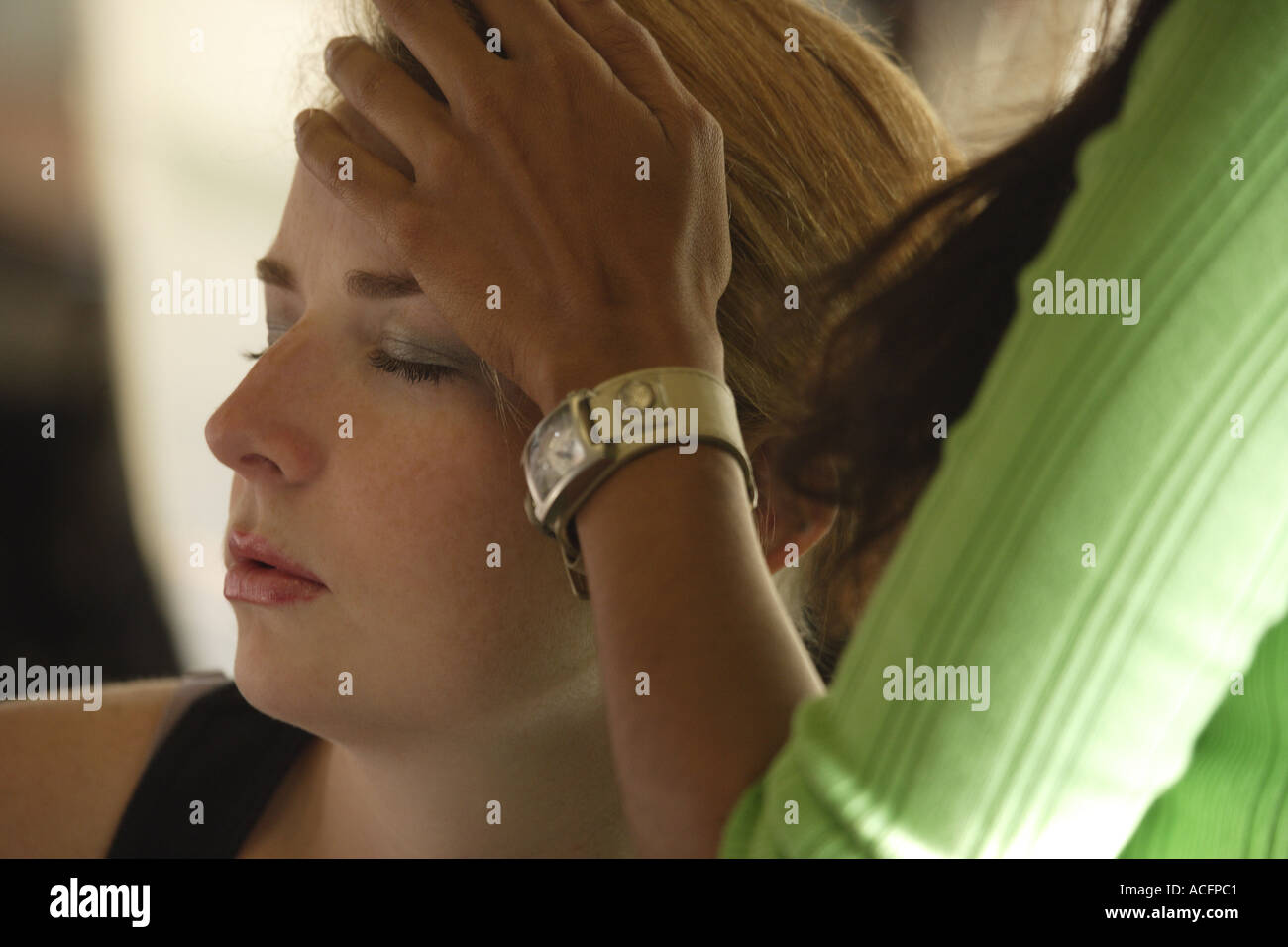 Woman with hand on another woman s forehead Stock Photo