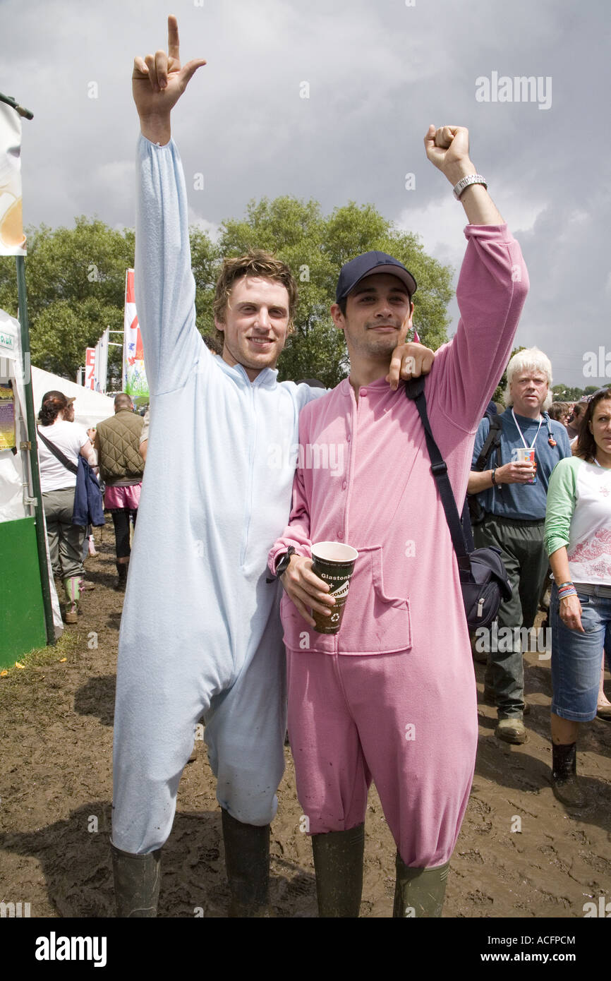 Two happy guys dressed in baby grows or jumpsuits  mud at the Glastonbury festival 2007 Stock Photo