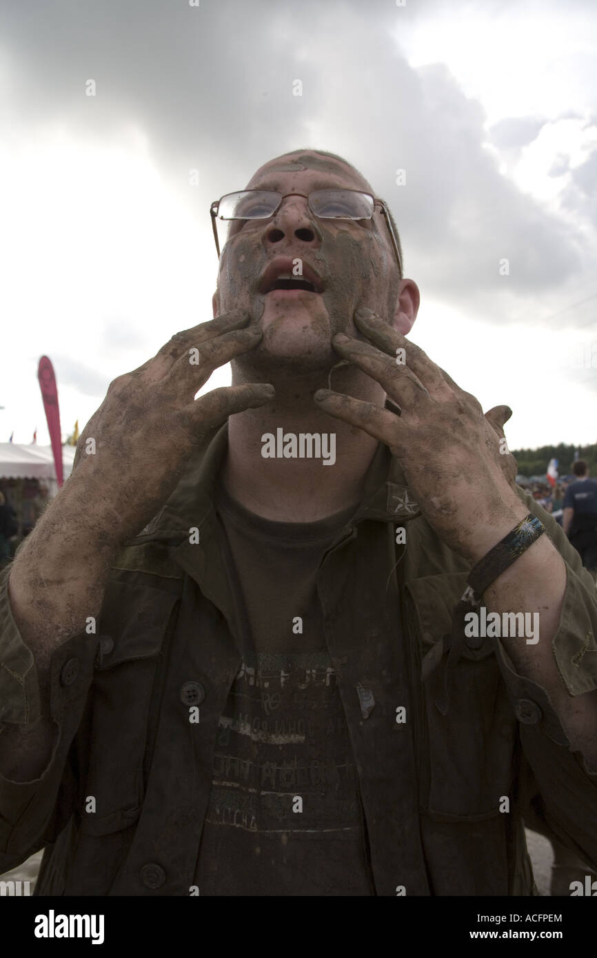 A man wearing glasses with his face covered in mud at the Glastonbury Festival 2007. Stock Photo