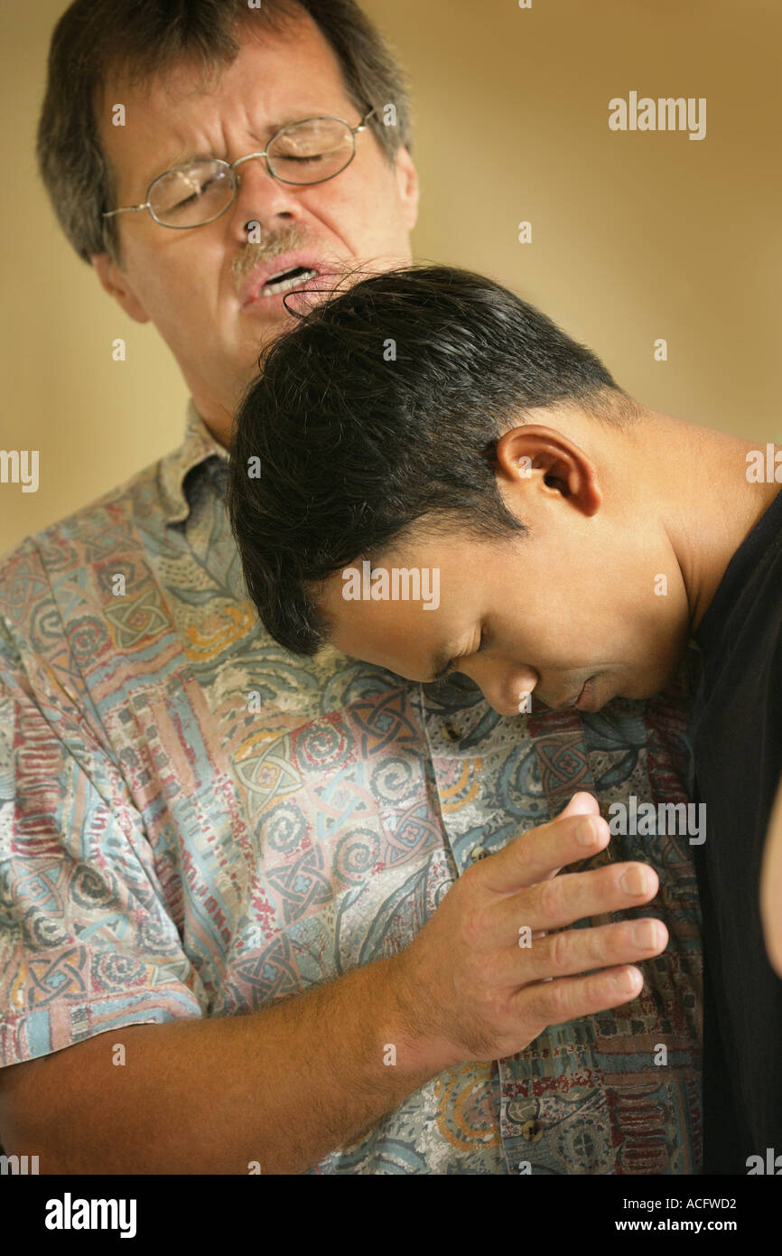 Man praying with teenager Stock Photo