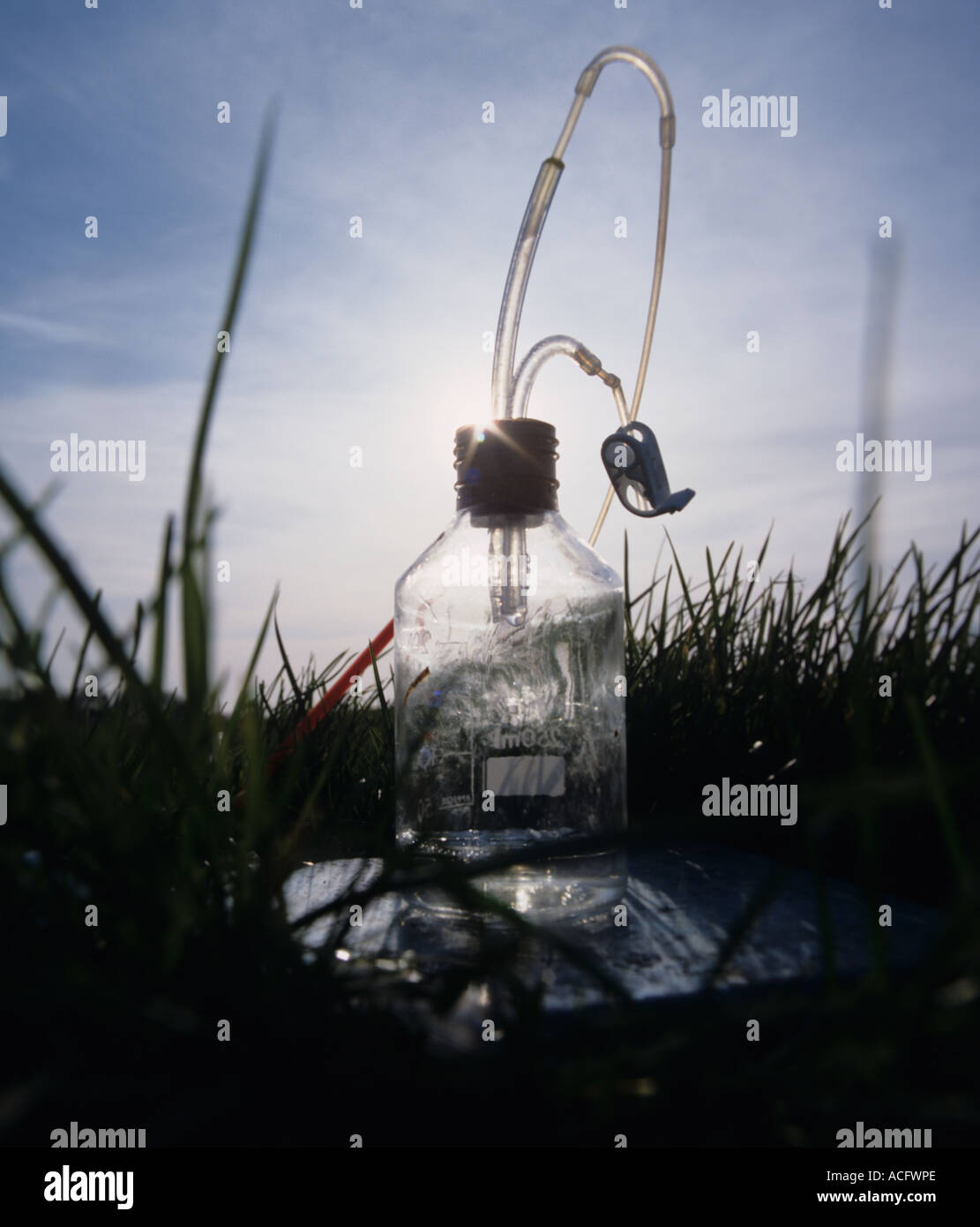 Bottle used to collect leachate from porous pot under grass Stock Photo