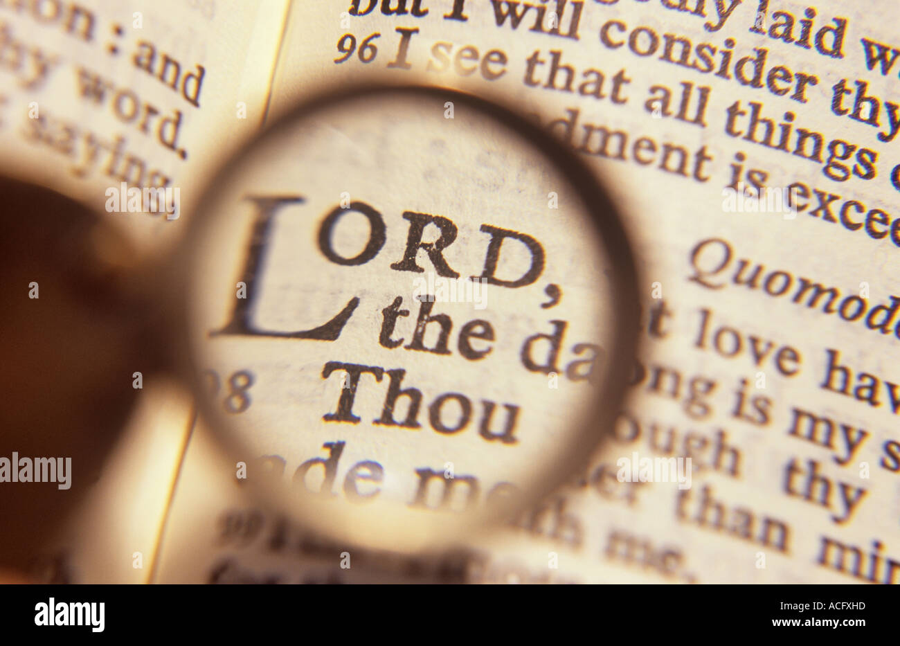 Close up of a pocket magnifier held over a Holy Bible and magnifying particularly the words Lord and Thou Stock Photo