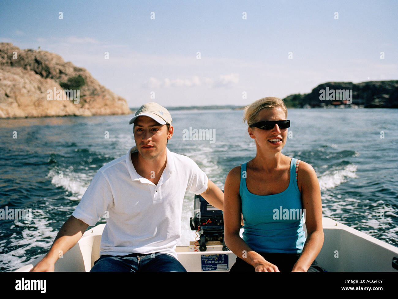 A couple driving a motorboat Stock Photo - Alamy