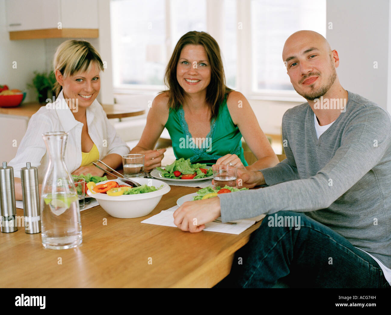 Three people having dinner Stock Photo - Alamy