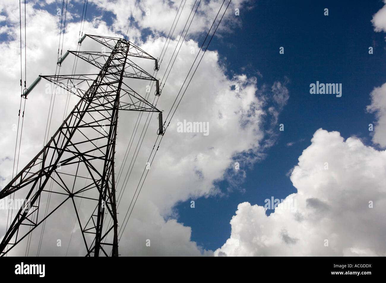 Electricity pylon against blue sky and clouds Stock Photo