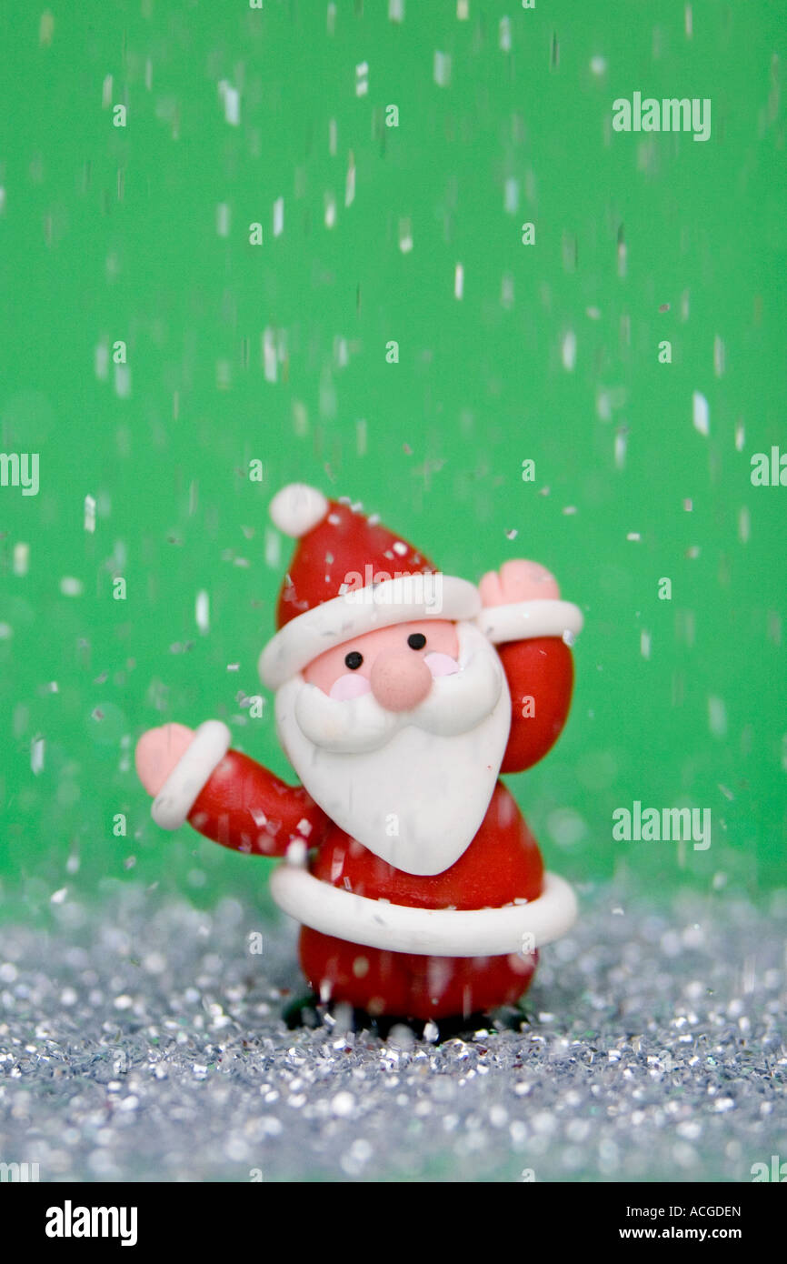 Father Christmas decoration against green surrounded by glitter Stock Photo