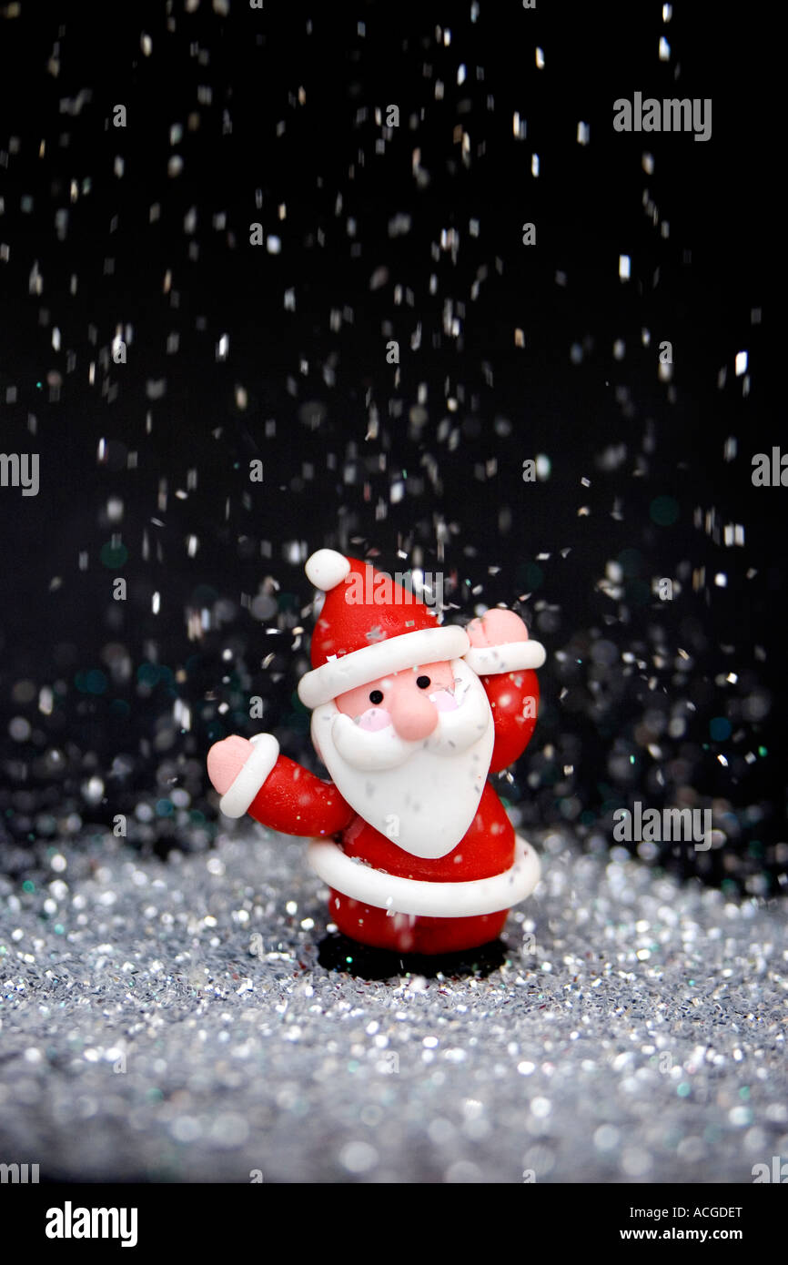 Father Christmas decoration against black surrounded by glitter Stock Photo