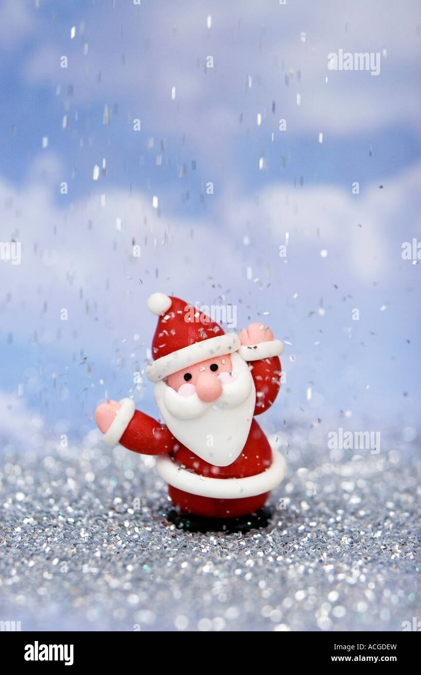 Father Christmas decoration against blue surrounded by glitter Stock Photo