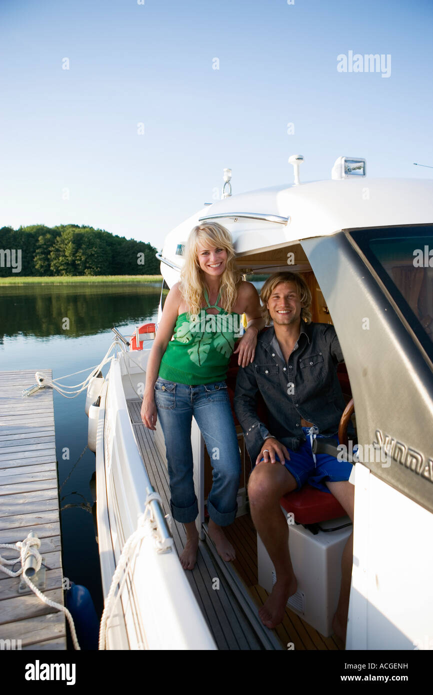 A couple in a motorboat smiling looking at the camera Stock Photo - Alamy