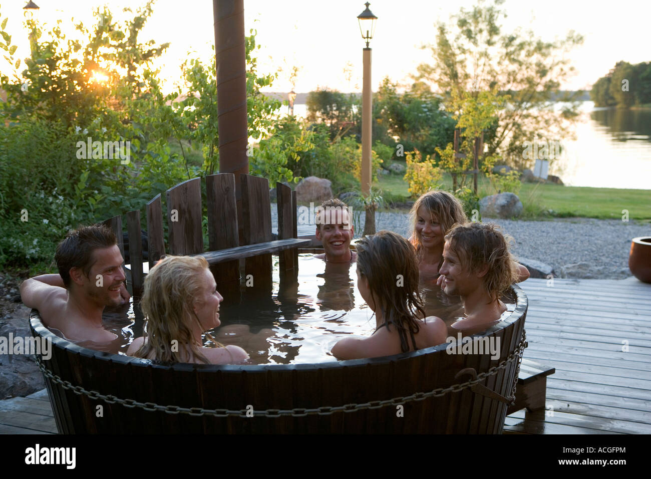 A group of people bathing in a barrel outdoors. Stock Photo