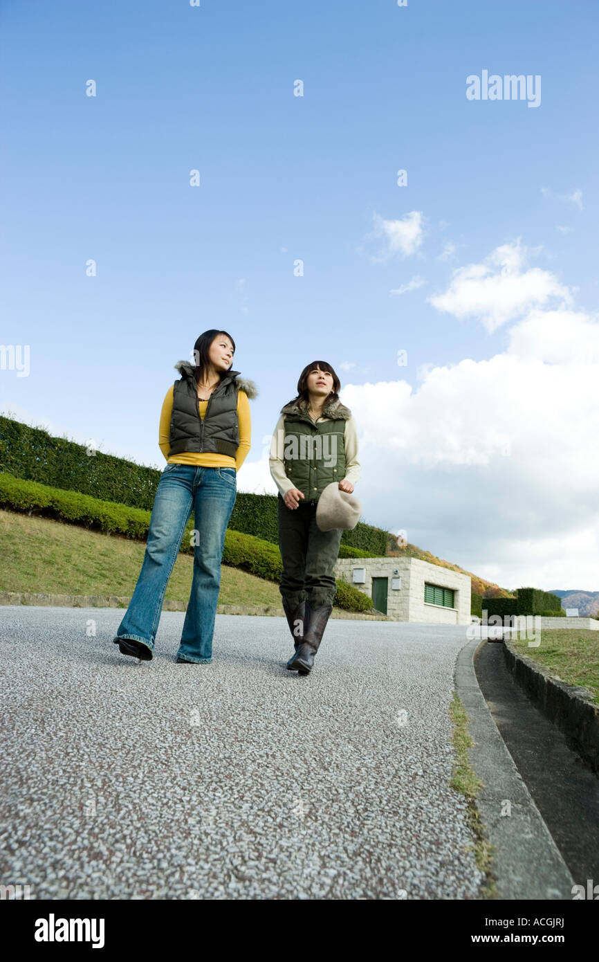 Two young women walking Stock Photo - Alamy