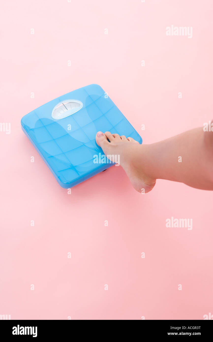 Woman stepping on bathroom scale Stock Photo Alamy