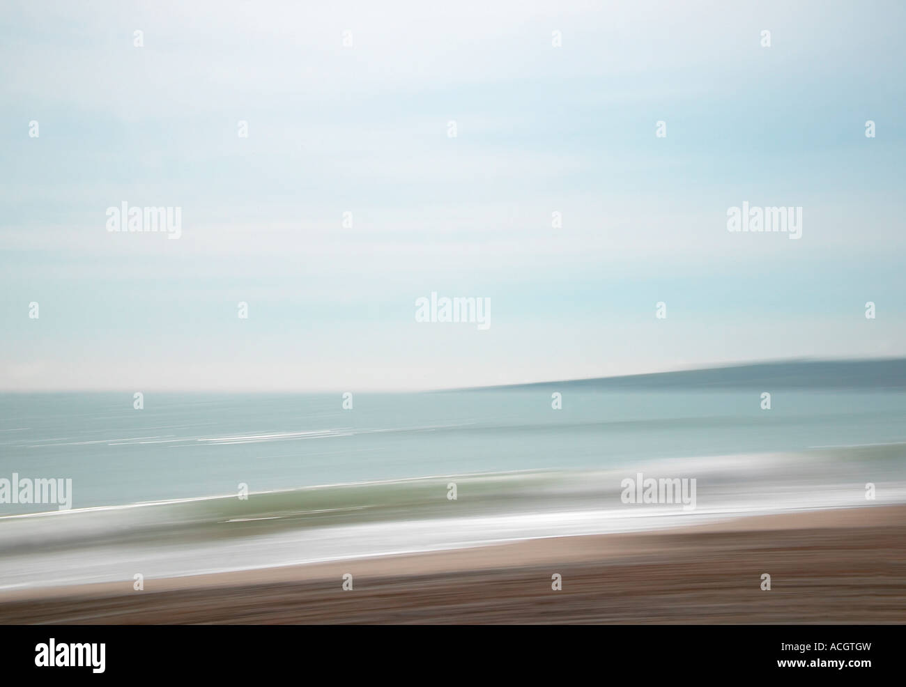 An english coastal shot with sand and sea. Blue sky and waves crashing onto the beach Stock Photo