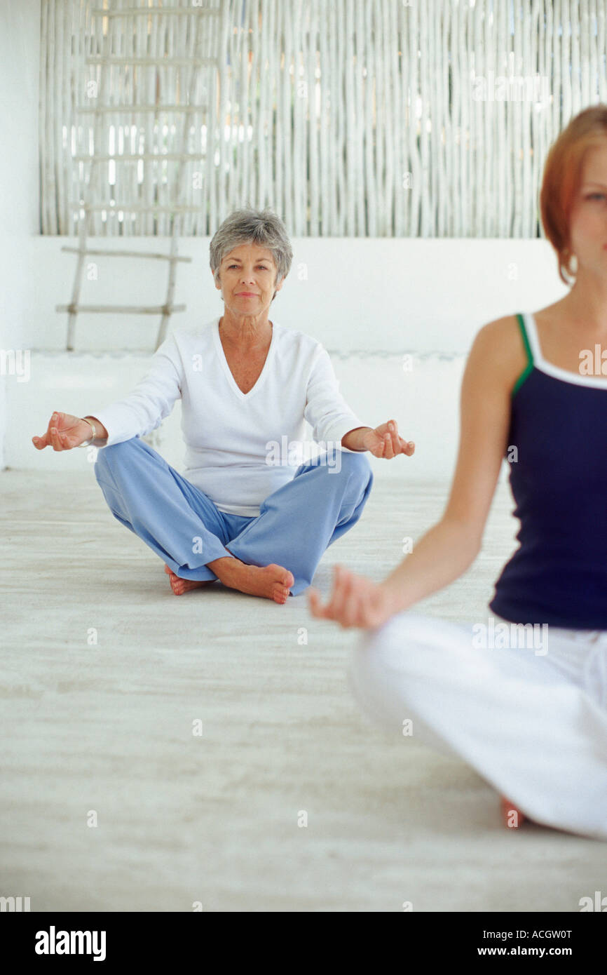Smiling women in lotus position yoga Stock Photo