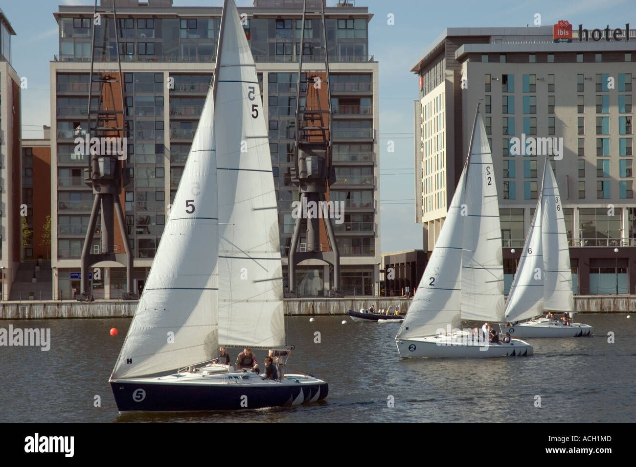 Sailing boats passing hotels and apartments near the Excel Exhibition Centre at Royal Victoria Dock London UK Stock Photo