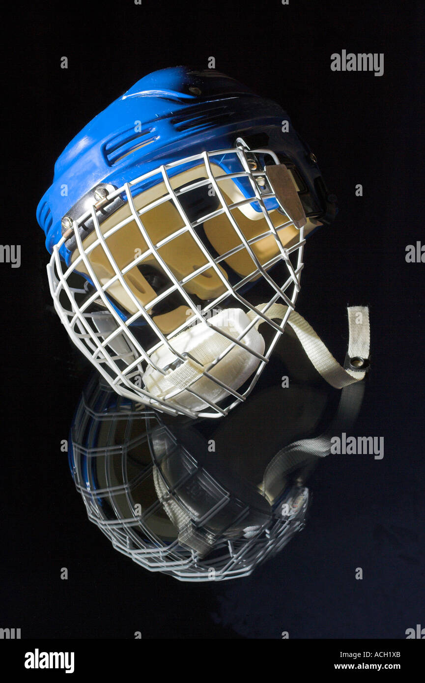 blue ice hockey helmet with metal mask resting on black mirror background Stock Photo