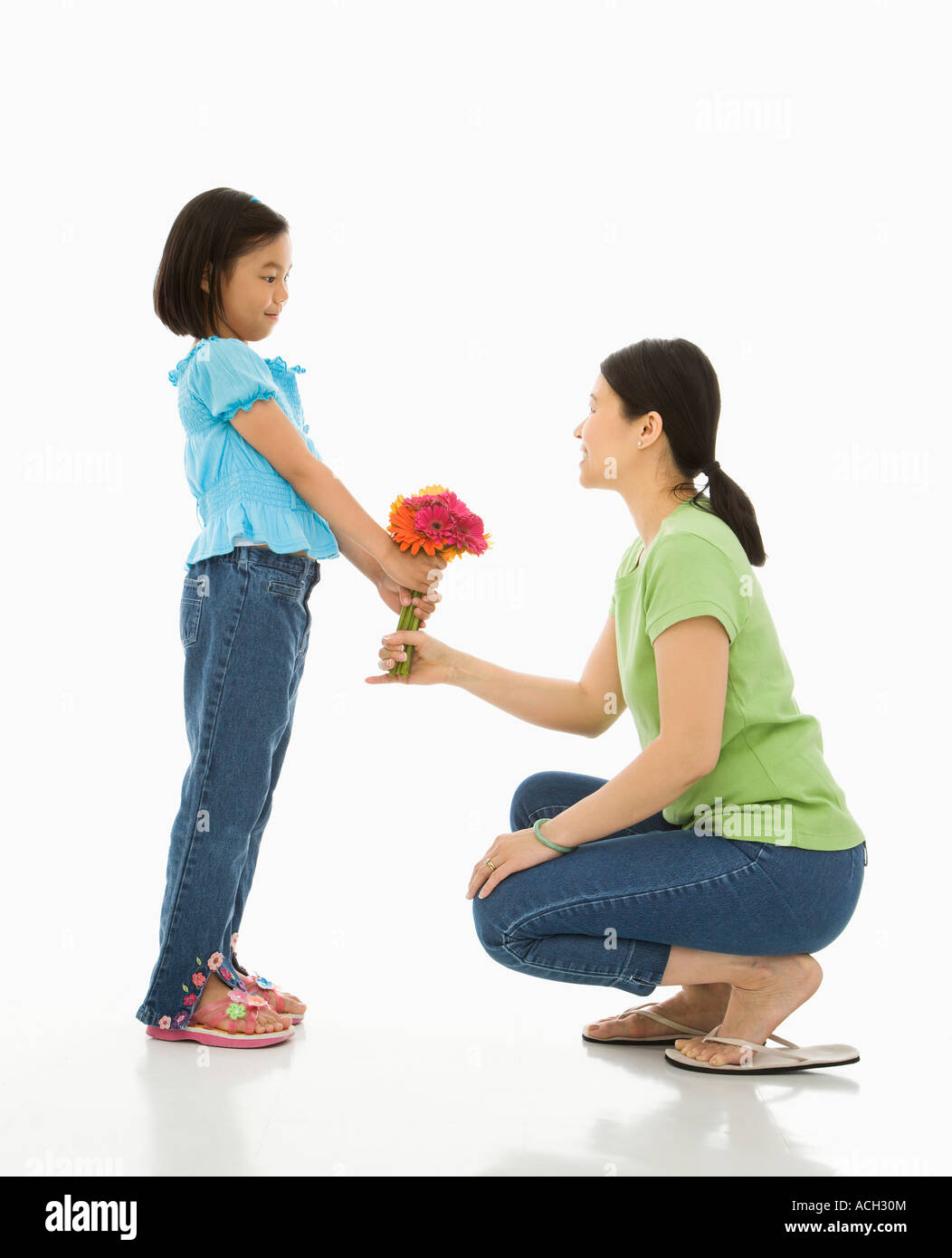 Asian girl handing bouquet of flowers to her mother Stock Photo Alamy