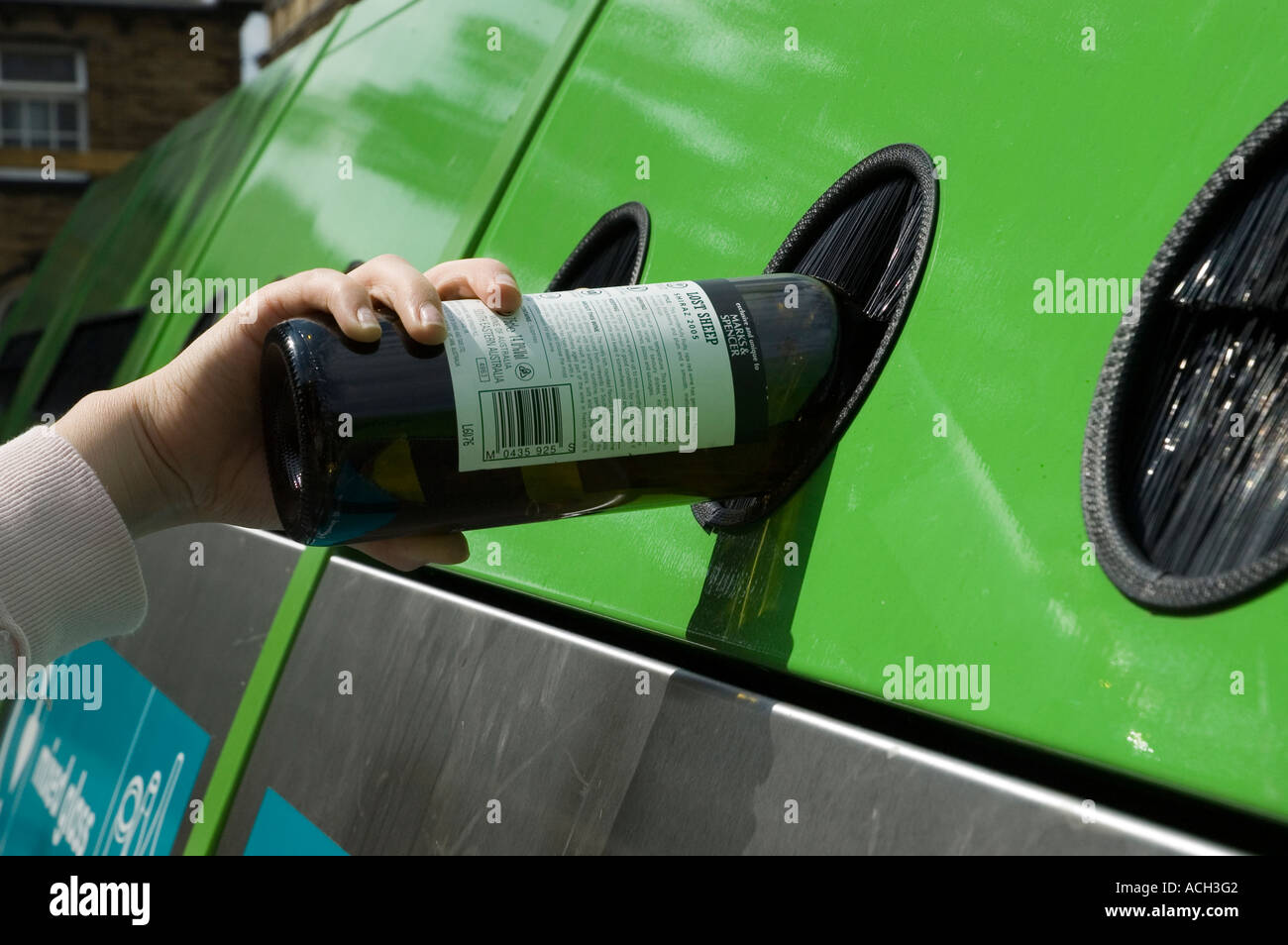 A bottle being placed into a bottle bank Stock Photo Alamy