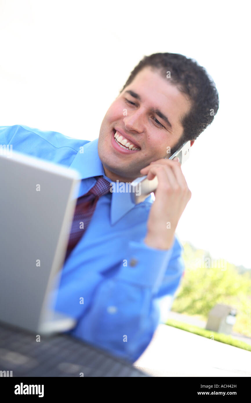 Young businessman using laptop and cell phone Stock Photo