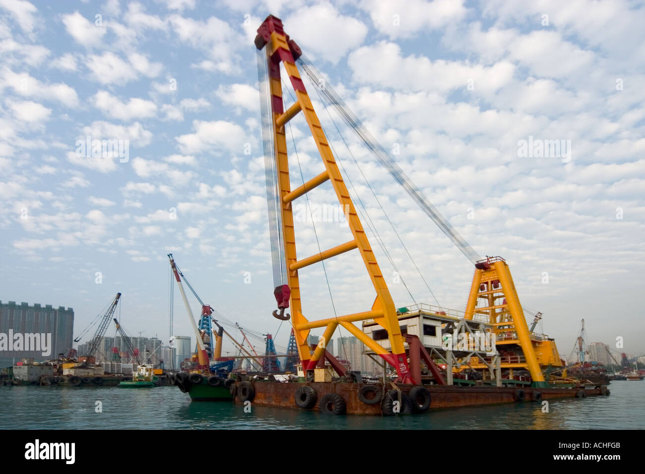 Heavy Lift Crane Barge in Kowloon Typhoon Shelter with Blue Sky and fluffy clouds Hong Kong Stock Photo