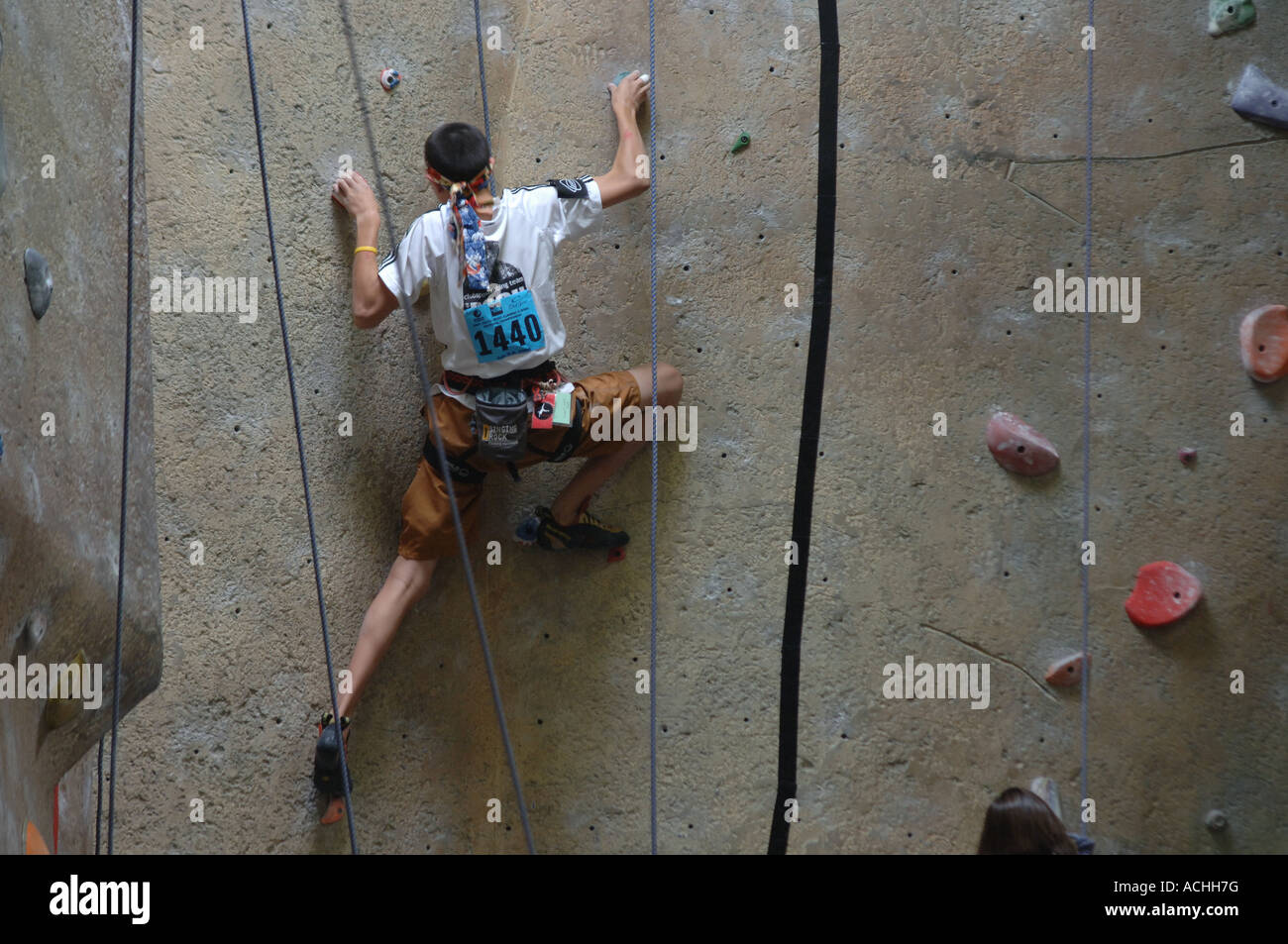Young man climbing a wall at indoor climbing facility at a climbing